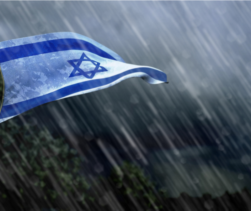 Israeli flag waves in wind and rain